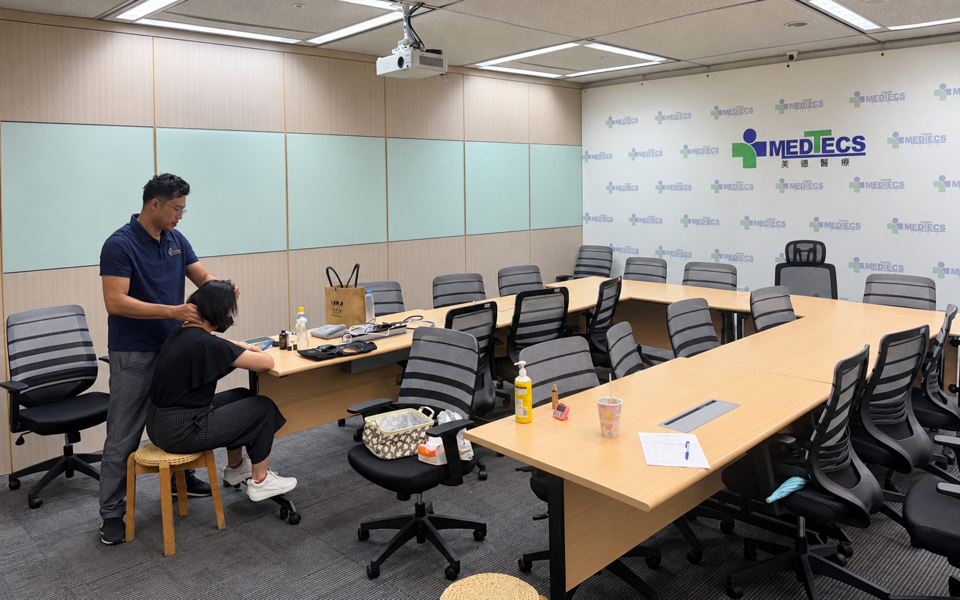 Medtecs 會議室裡,師資為坐在椅子上的同仁按摩肩頸